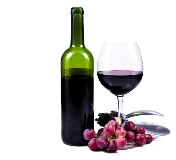 Glas wijn met rode wijn, fles wijn en druiven Stockfoto