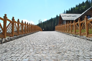 Cobblestone road with wooden fence and lanterns clipart