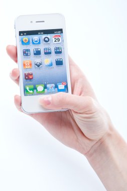 Female hands with a manicure keeps white iphone 4 on a white clipart