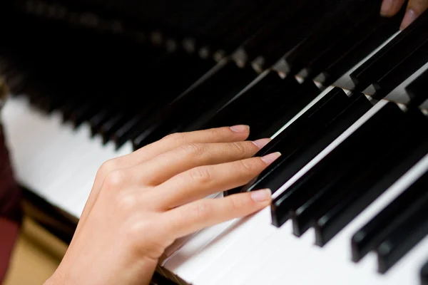 A mão da mulher gentil em teclas de piano — Fotografia de Stock