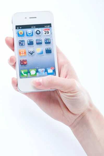 Vrouwelijke handen met een manicure houdt witte iphone 4 op een witte — Stockfoto