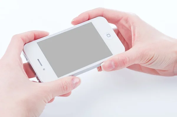 Female hands with a manicure keeps white iphone 4 on a white — Stock Photo, Image