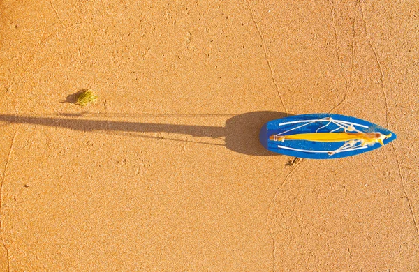 Маленький іграшковий човен стоїть на піщаному пляжі — стокове фото
