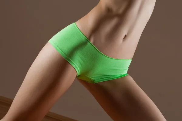 Schönheit und perfekte Frau mit idealem Fitness-Körper in grünem Höschen — Stockfoto