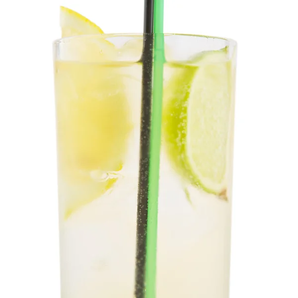 A delicious cocktail with slices of lemon and lime in a glass be — Stock Photo, Image
