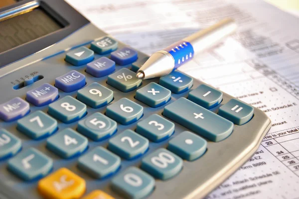 Calcolatrice e penna fiscale Fotografia Stock