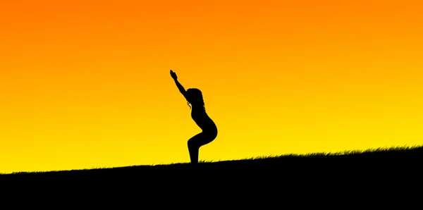 Silhouette eines schönen Mädchens, das im Sonnenuntergang Yoga praktiziert — Stockfoto