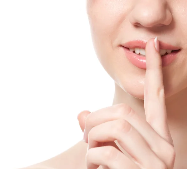 Ung kvinna med ett finger nära hennes läppar — Stockfoto