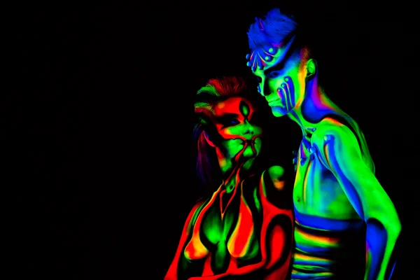 Mann und Frau mit fluoreszierendem Körperschmuck. schwarzer Hintergrund. Studio — Stockfoto