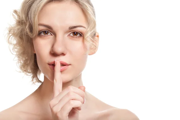 Ung kvinna med ett finger nära hennes läppar — Stockfoto