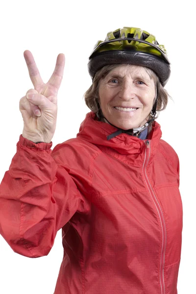 Happy retired woman in bicycle helmet showing peace sign — Stock Photo, Image