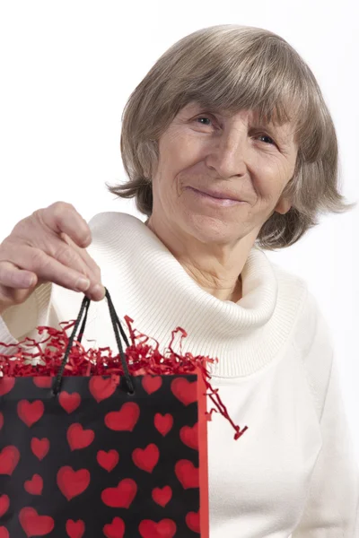 Senior vrouw verhogen geschenk tas — Stockfoto