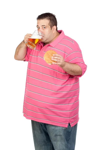 Gordo bebendo um pote de cerveja e comendo hambúrguer — Fotografia de Stock