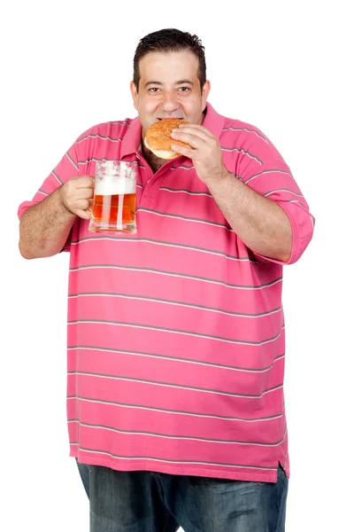 Fat man drinking a jar of beer and eating hamburger — Stock Photo, Image