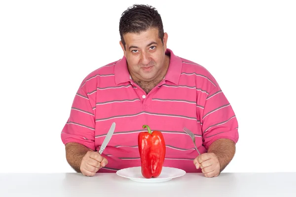 Fett man äter en röd paprika — Stockfoto