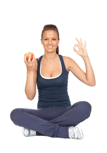 Chica gimnasia con una manzana sentada con las piernas cruzadas — Foto de Stock