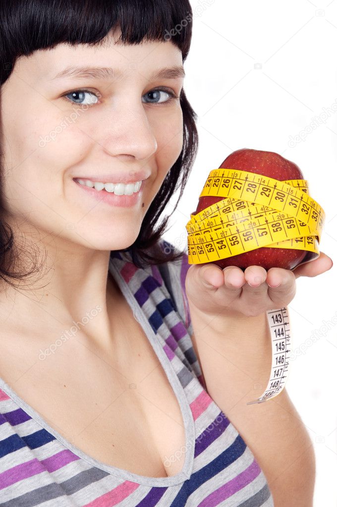 Attractive girl with apple and tape measure in the hand