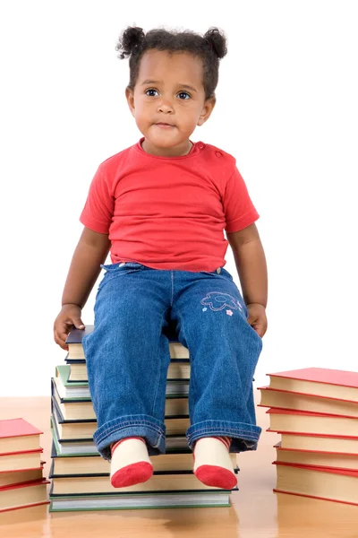 Bambino seduto su un mucchio di libri — Foto Stock