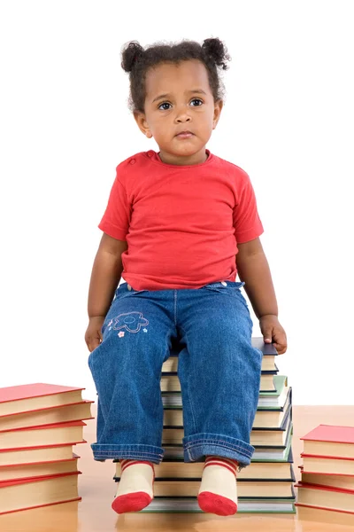 Dítě sedí na hromadě knih — Stock fotografie