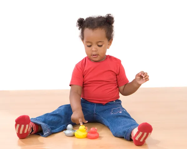 Girl playing with three ducks of plastic — Stock Photo, Image