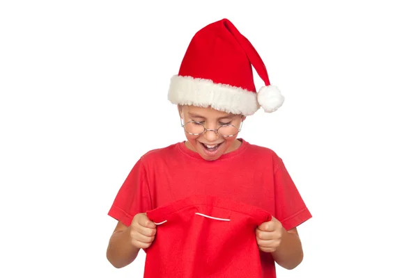 Criança surpresa com chapéu de Santa olhando no saco — Fotografia de Stock