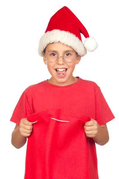 Criança surpresa com chapéu de Santa olhando no saco — Fotografia de Stock