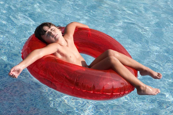 Criança relaxada na piscina — Fotografia de Stock