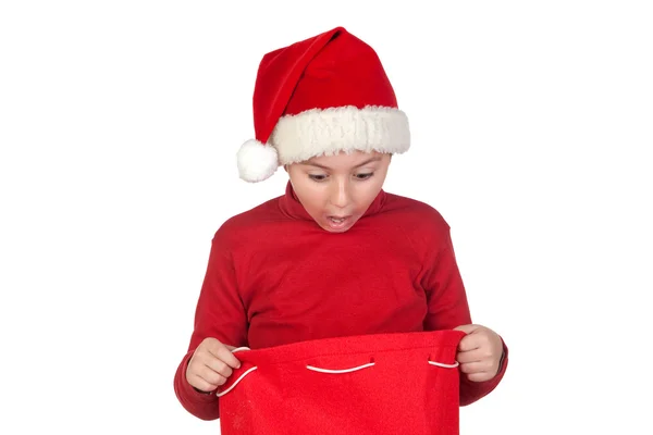 Chico asombrado mirando en la bolsa de Navidad — Foto de Stock