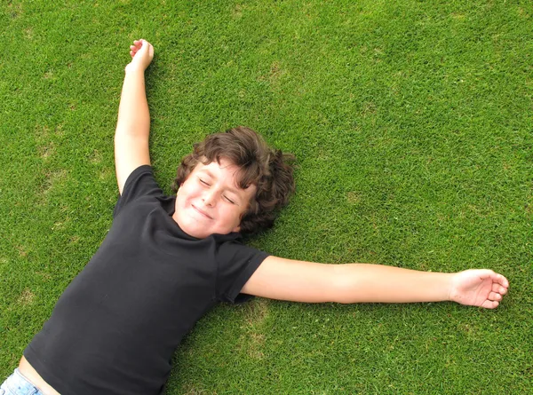 Счастливый ребенок отдыхает на траве — стоковое фото