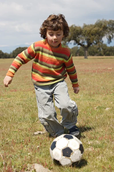 Criança jogando futebol — Fotografia de Stock