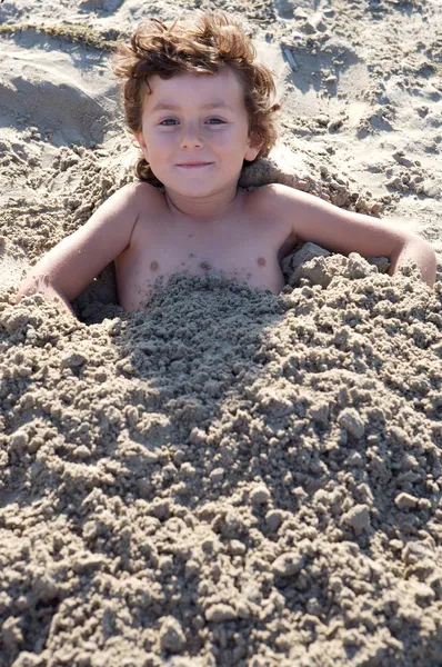 Kind im Sand begraben — Stockfoto