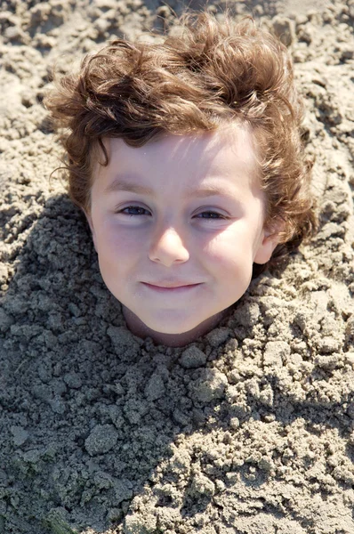 Niño enterrado en la arena — Foto de Stock
