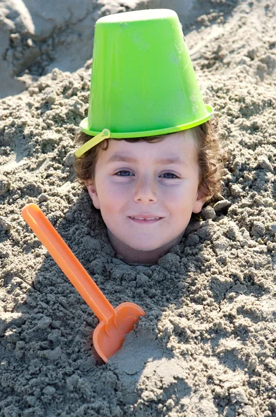 Niño enterrado en la arena — Foto de Stock