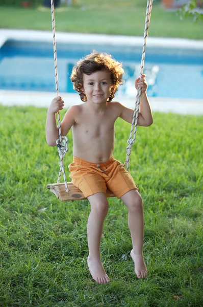 Niño jugando en un columpio — Foto de Stock