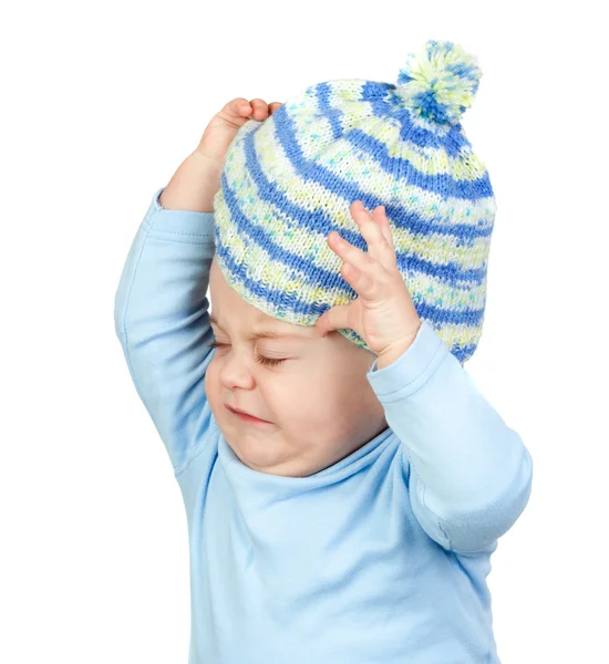Angry baby taking off a wool cap — Stock Photo, Image