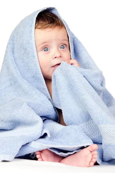 Красивая малышка с голубыми глазами, покрытыми полотенцем — стоковое фото