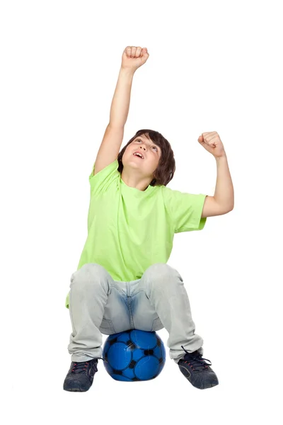 Criança vencedora sentada na bola de futebol azul — Fotografia de Stock