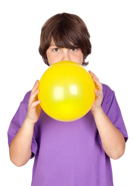 Funny boy blowing up a yellow balloon — Stock Photo, Image