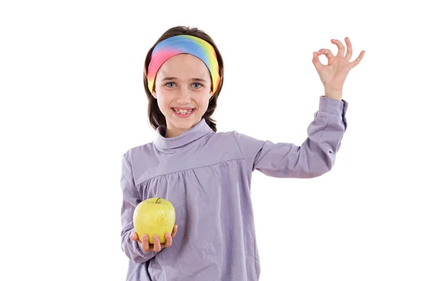 Menina adorável com uma maçã dizendo OK — Fotografia de Stock