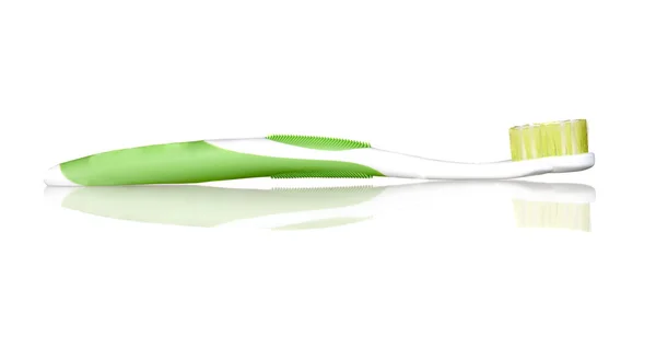 Зеленая зубная щетка с отражением на полу — стоковое фото
