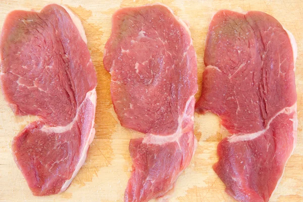 Três bifes de carne de porco salgada crua — Fotografia de Stock