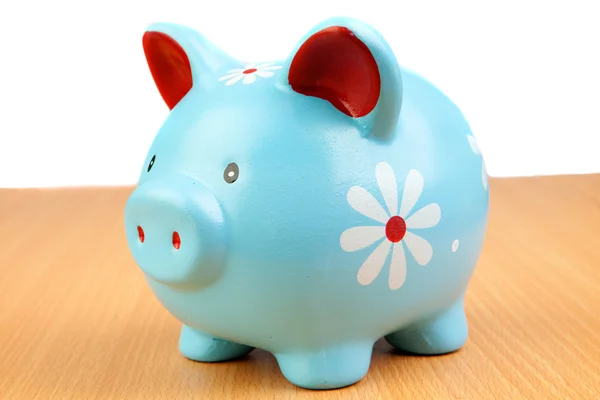 Blue piggy-bank on a wooden table — Stock Photo, Image