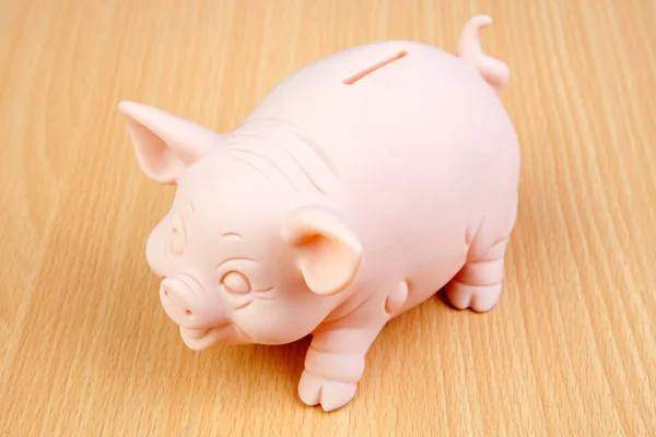 Piggy-bank em uma mesa de madeira — Fotografia de Stock