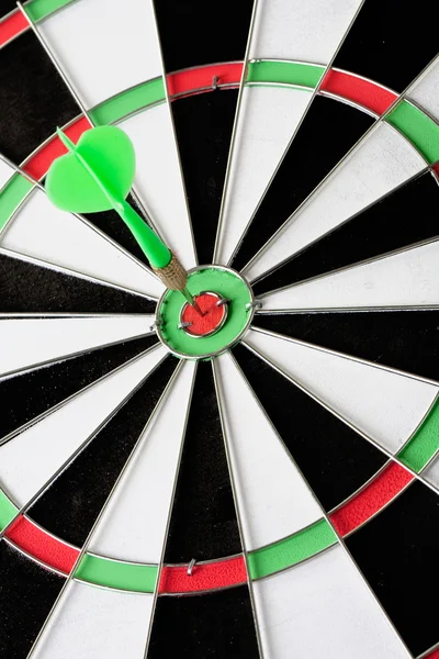 Green dart punctured in the center — Stock Photo, Image