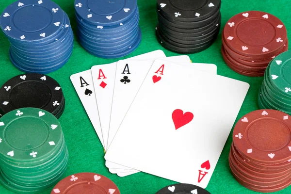 Čtyři esa a poker skládaný čipy mnoha barev — Stock fotografie