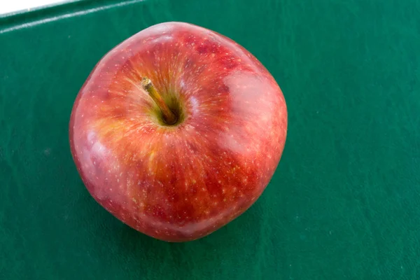 Яблоко красное на зеленой книге — стоковое фото