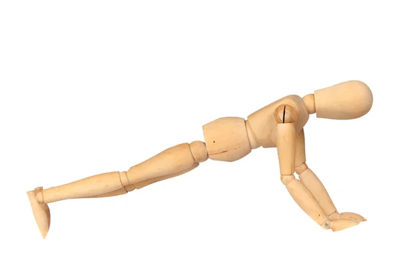Jointed wooden mannequin doing push-ups — Stock Photo, Image