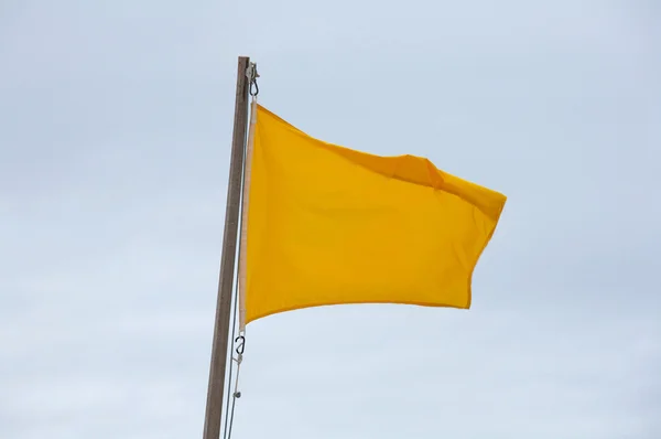 stock image Yellow flag on the beach