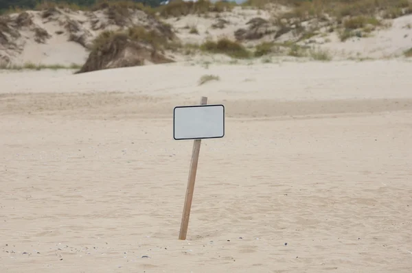 Одинокий плакат в песке — стоковое фото