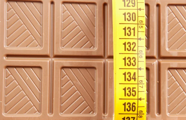 Chocolate bar and tape measure — Stock Photo, Image